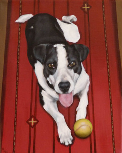 Black and white dog on red rug with tennis ball.